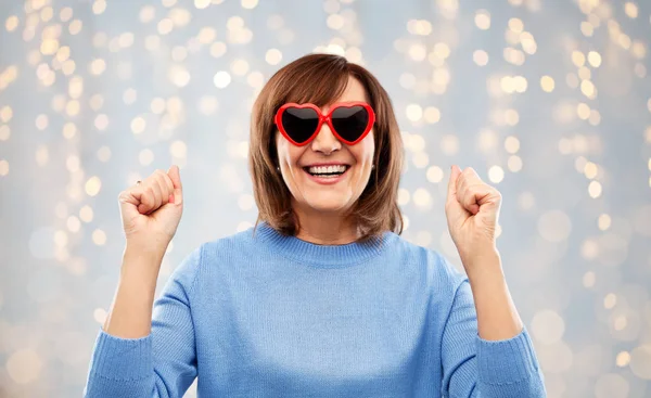 Mulher sênior sorridente em óculos de sol em forma de coração — Fotografia de Stock