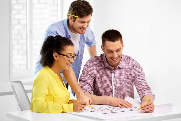 Creative team with blueprint working at office — Stock Photo, Image