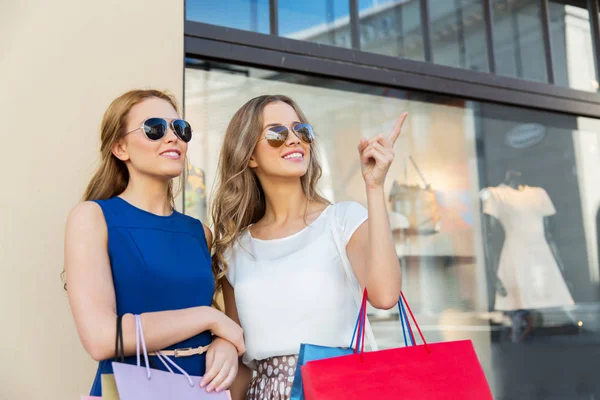 Mujeres felices con bolsas de compras en la tienda —  Fotos de Stock