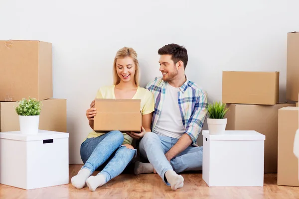 Feliz pareja con cajas mudándose a un nuevo hogar — Foto de Stock