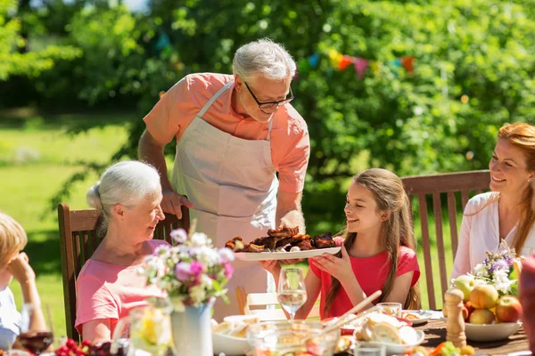 Familia cenando o barbacoa en el jardín de verano —  Fotos de Stock