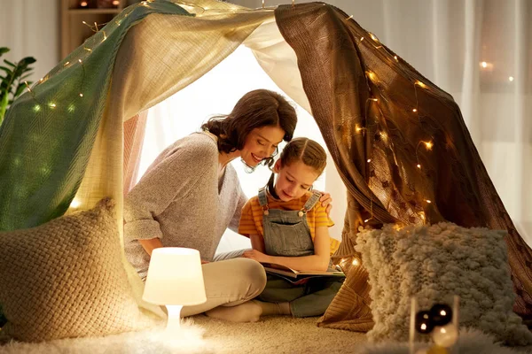 快乐家庭阅读书在儿童帐篷在家 — 图库照片