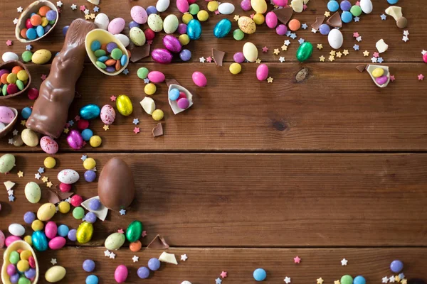 Choklad ägg, påsk kanin och godis på trä — Stockfoto