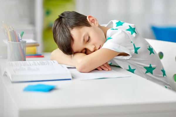 Trött student pojken sover på bordet hemma — Stockfoto