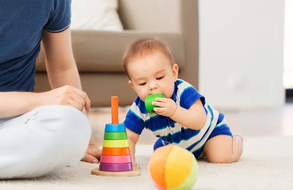 Menino com pai e brinquedo pirâmide em casa — Fotografia de Stock