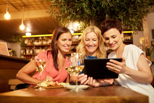 Ženy s tablet pc v vinárna nebo restaurace — Stock fotografie