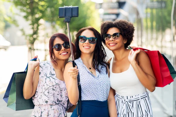 Alışveriş çantalı kadınlar dışarıda selfie çekiyorlar. — Stok fotoğraf