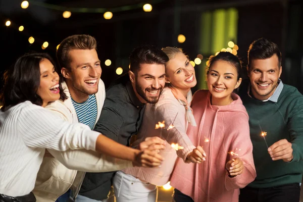 Amici felici con scintille alla festa sul tetto — Foto Stock