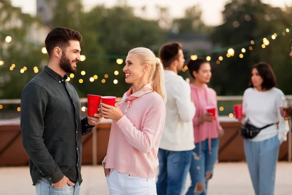 Amis avec des boissons dans des tasses de fête sur le toit — Photo