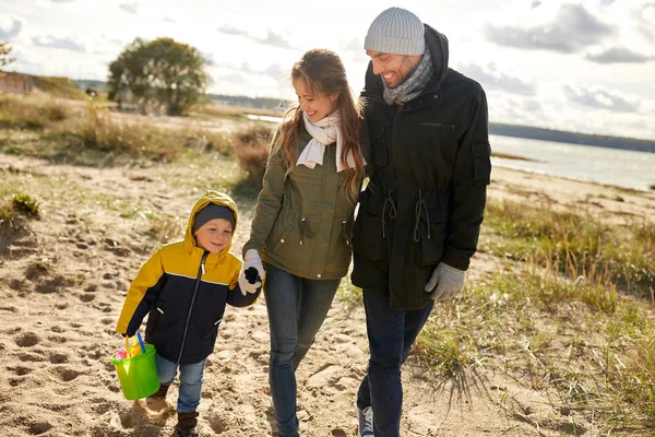 Lycklig familj promenader längs hösten beach — Stockfoto