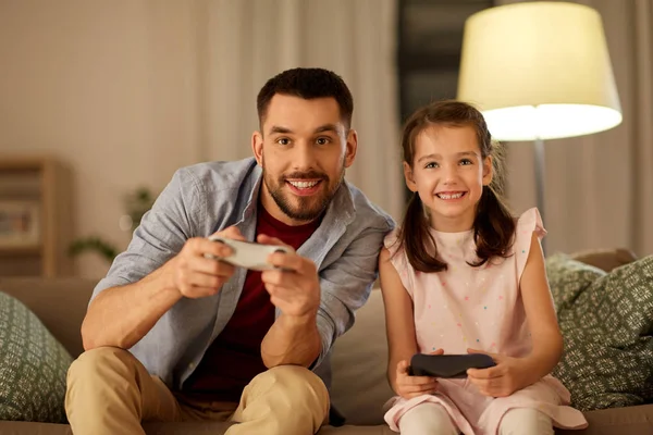 Père et fille jouer à un jeu vidéo à la maison — Photo