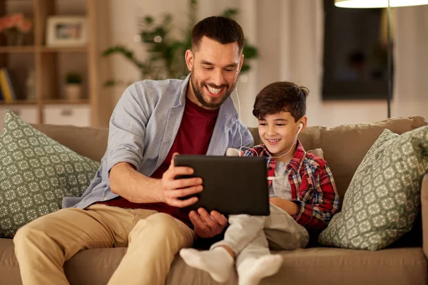 Pai e filho ouvindo música no tablet pc — Fotografia de Stock