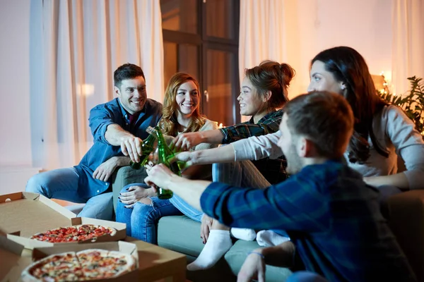 Amigos felizes com bebidas e festa de pizza em casa — Fotografia de Stock