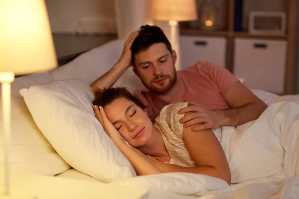 Man zijn slapende vrouw wakker in bed thuis — Stockfoto