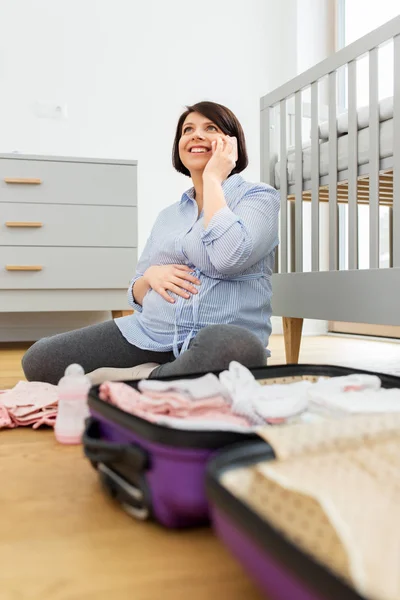 Donna incinta imballaggio borsa dell'ospedale e chiamando — Foto Stock