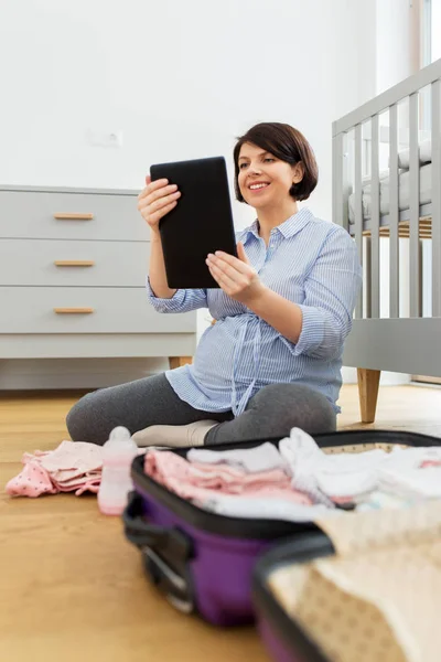 Mulher grávida com tablet pc embalagem saco hospitalar — Fotografia de Stock