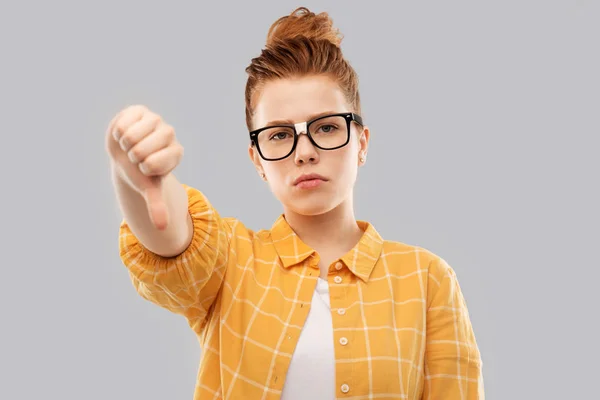 Rojo estudiante chica en gafas mostrando los pulgares hacia abajo — Foto de Stock