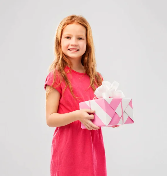 Leende rödhåriga flicka med födelsedags present — Stockfoto