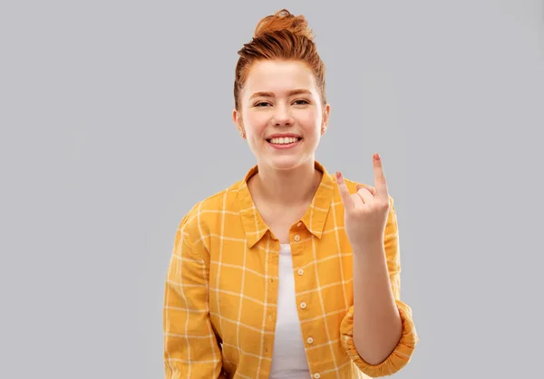 Feliz vermelho peludo adolescente mostrando gesto de rock Imagem De Stock