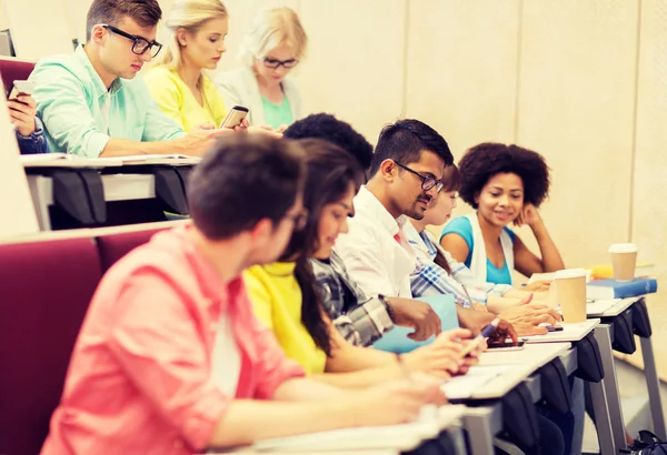 Grupp studenter med kaffe skriva på föreläsning — Stockfoto