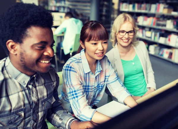 Estudantes internacionais com computadores na biblioteca — Fotografia de Stock