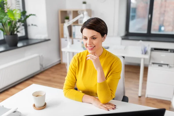 Счастливая бизнесвумен, сидящая за офисным столом — стоковое фото