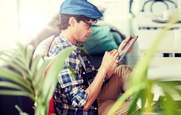 Muž s tablet pc sedí u stolu v kavárně — Stock fotografie