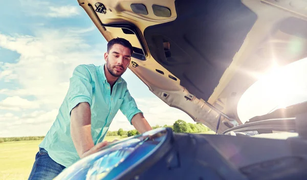 Mann mit offener Motorhaube von kaputtem Auto auf dem Land — Stockfoto