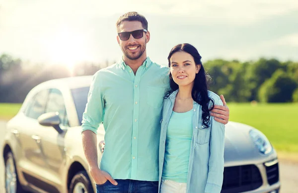 Lycklig man och kvinna som kramas på bil — Stockfoto