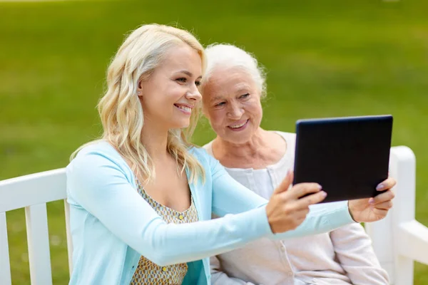 Tochter mit Tablet-PC und Mutter im Park — Stockfoto