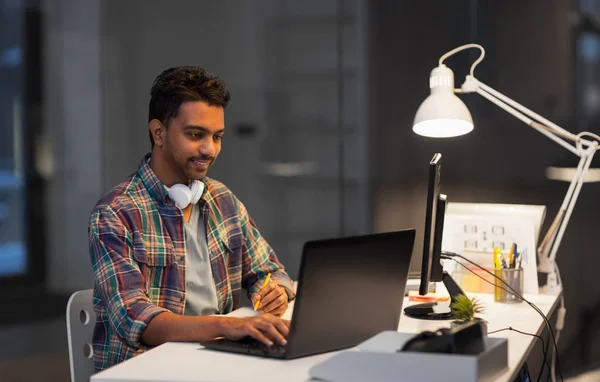 Hombre creativo con el ordenador portátil que trabaja en la oficina de noche —  Fotos de Stock