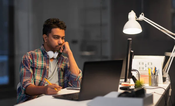 Creatieve man met laptop werken op kantoor van de nacht — Stockfoto