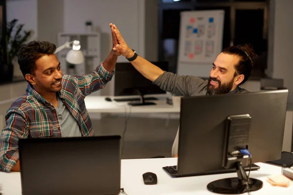 Creative team making high five at night office — Stock Photo, Image