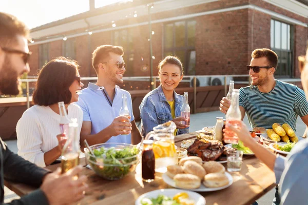 Amigos felizes com bebidas ou festa bbq no telhado — Fotografia de Stock