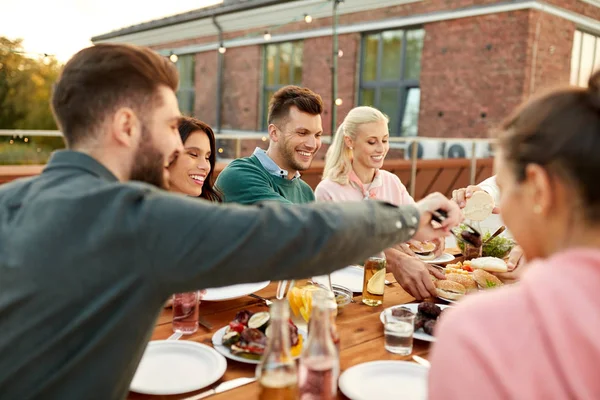 Amis manger des hamburgers au dîner sur le toit — Photo