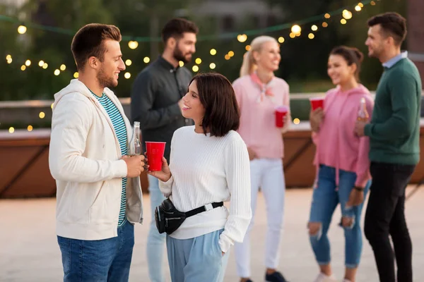 Amis avec des boissons dans des tasses de fête sur le toit — Photo