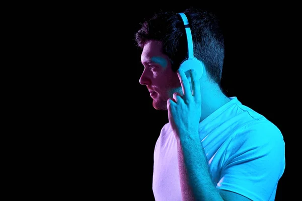 Hombre en auriculares sobre luces de neón del club nocturno —  Fotos de Stock