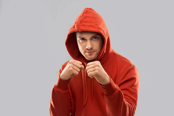 Mann in rotem Kapuzenpulli kämpft mit Fäusten oder boxt — Stockfoto