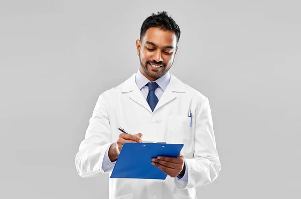 Smiling indian doctor or scientist with clipboard Stock Picture