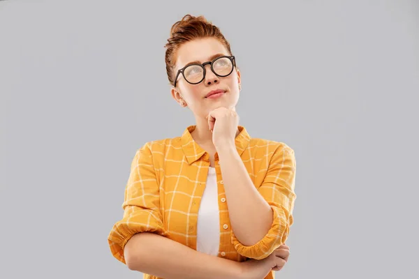 Thinking redhead teenage student girl in glasses — Stock Photo, Image