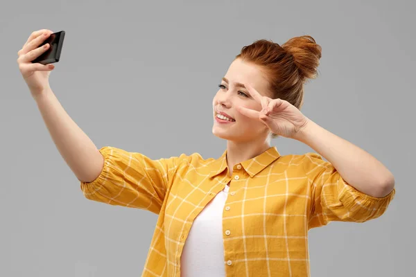 Roodharige tiener meisje dat selfie neemt door smartphone — Stockfoto