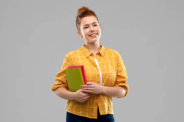 Sorridente dai capelli rossi adolescente studentessa con libri — Foto Stock
