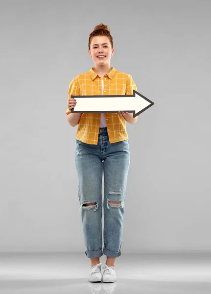 Roodharige tiener meisje met pijl naar rechts tonen — Stockfoto