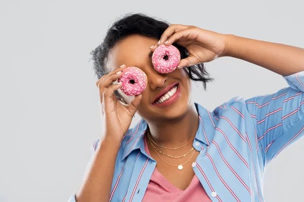 Happy african american woman with eyes of donuts — Stock Photo, Image