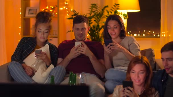 Vänner med smartphone som du tittar på tv hemma — Stockvideo