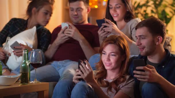 Amis avec smartphone regarder la télévision à la maison — Video