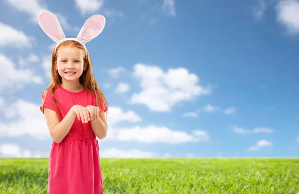 Happy red haired girl wearing easter bunny ears — Stock Photo, Image