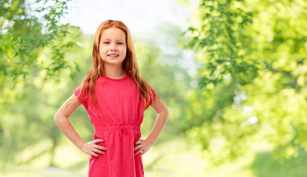 Uśmiechający się rudowłosy dziewczyna stwarzających w różowej sukience — Zdjęcie stockowe