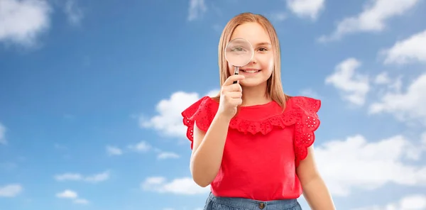 Glückliches Mädchen, das durch das Vergrößerungsglas schaut — Stockfoto