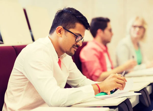 Group of students with notebooks in lecture hall — Stock Photo, Image